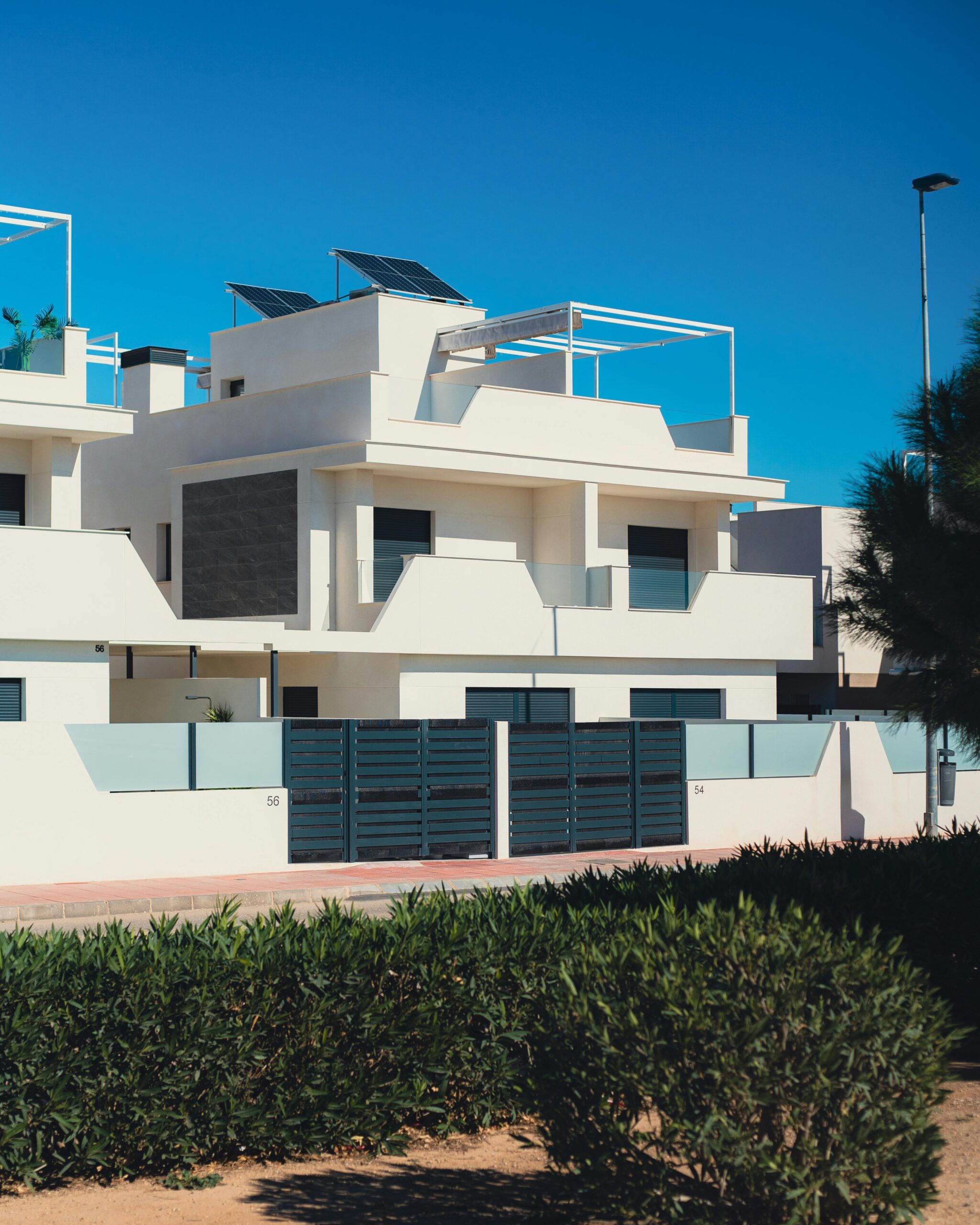 Contemporary white villas with solar panels in Santiago de la Ribera, Spain.